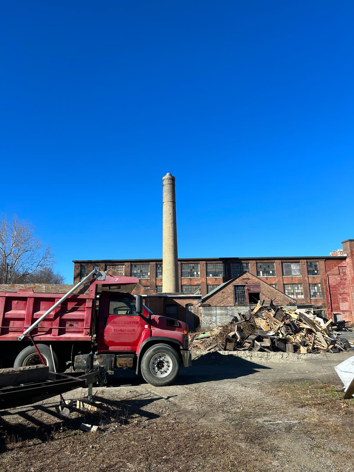 a large truck next to a pile of palletts